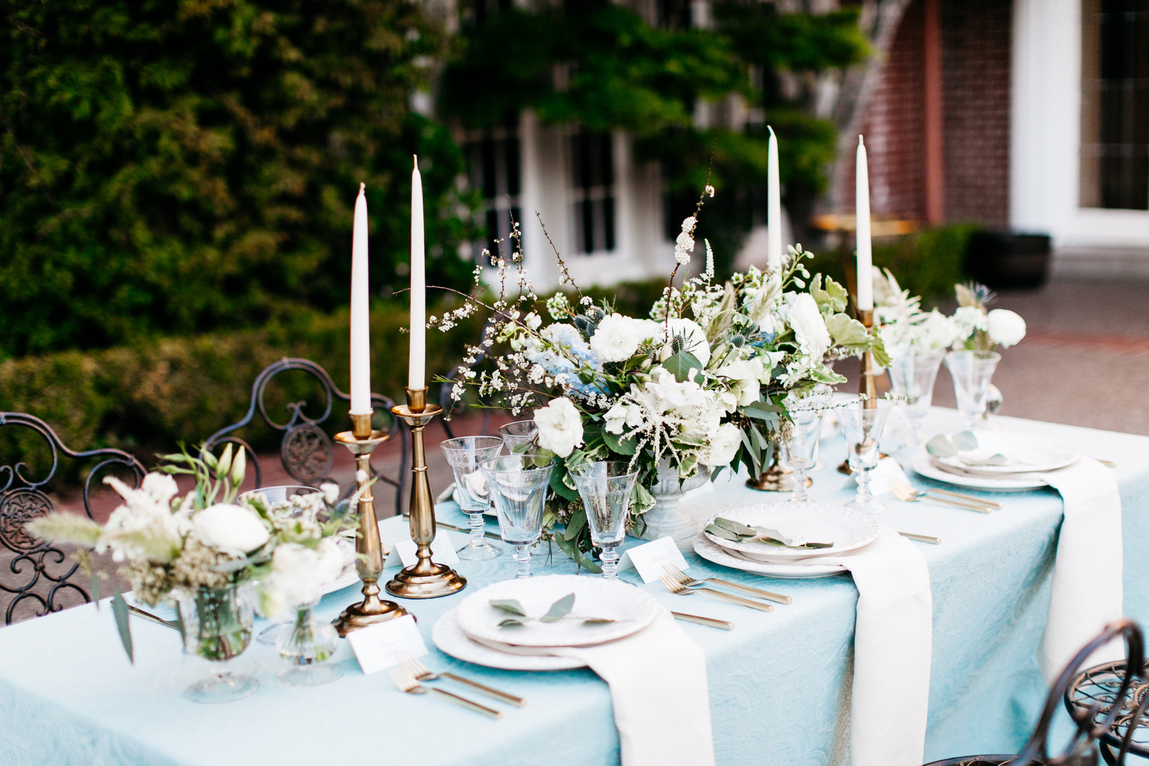 Romantic blue tablescape with gold candlesticks and white florals